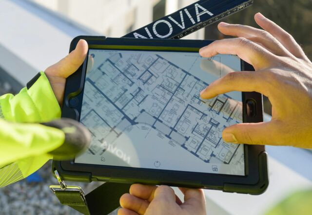 NOVIA GmbH Consulting und Baumanagement - Detailaufnahme: Grundriss auf Ipad. Hände eines Mitarbeiters zoomen Plan größer.